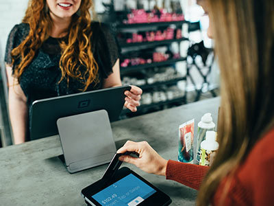 A woman paying with plastic at a boutique