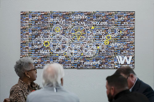 People standing near a poster of the event