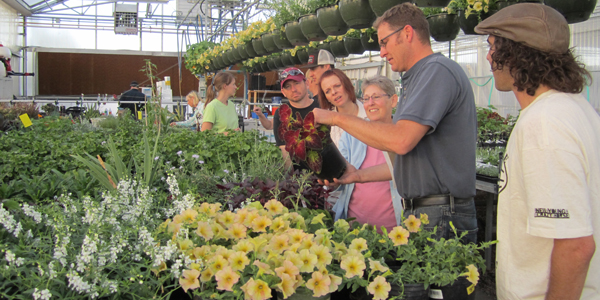 Instructor showing greenhouse plants to students