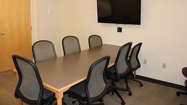 conference room with table, four chairs, and monitor