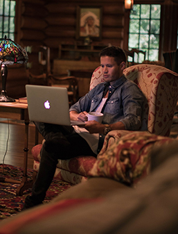 Man on laptop in a cabin